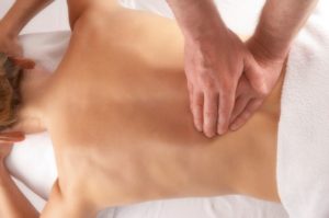 massage of the lower back on white linen