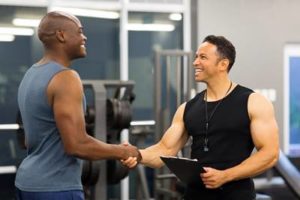 middle aged gym trainer greeting client